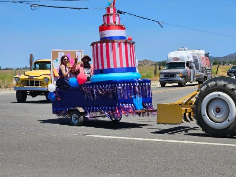 A patriotic float pulled by a tractor