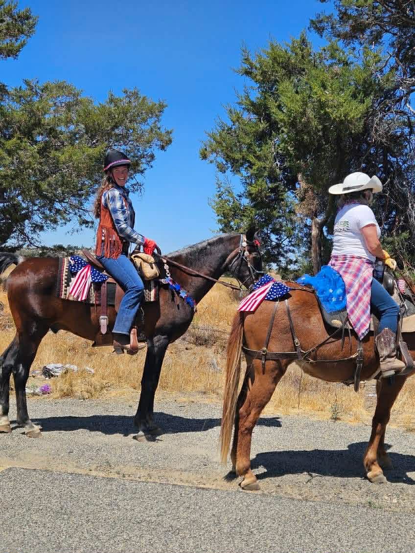 Two riders on horseback with American flags